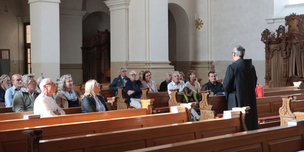 Bruder Markus erklärt interessierten Zuhörerinnen und Zuhörern die Besonderheiten der Klosterkirche Beuron im Rahmen einer Kirchenführung